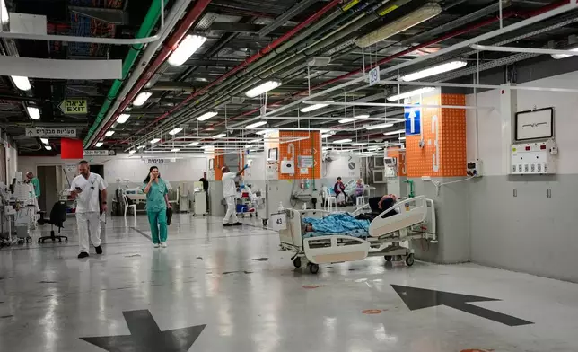 Medical staff transfer patients to a protected underground parking following an Iranian missile attack, at Ichilov Hospital in Tel Aviv, Israel, Monday, June 8, 2026. (AP Photo/Ohad Zwigenberg)