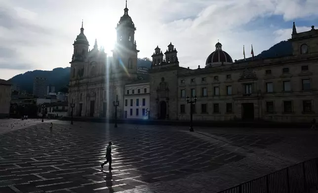 A police officer walks through Bolivar Square before polls open for the runoff election in downtown Bogota, Colombia, Sunday, June 21, 2026. (AP Photo/Fernando Vergara)
