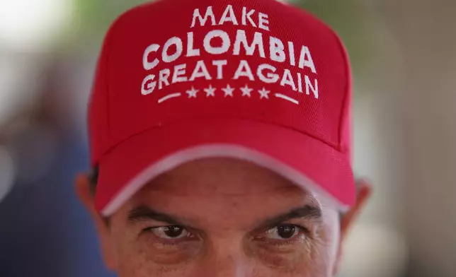 A voter wearing a "Make Colombia Great Again" cap waits in line during the runoff election in Barranquilla, Colombia, Sunday, June 21, 2026.(AP Photo/Ivan Valencia)