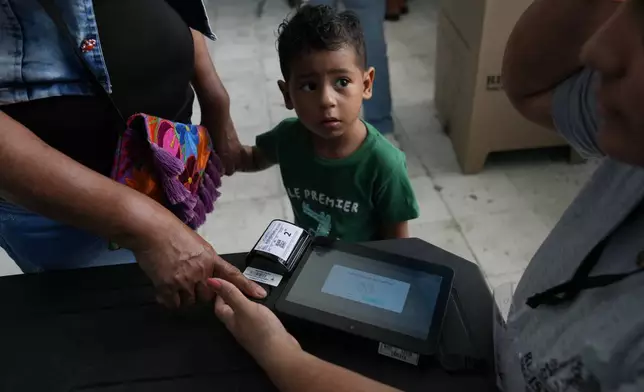 A voter has her ID checked before voting in the runoff election in Barranquilla, Colombia, Sunday, June 21, 2026. (AP Photo/Rodrigo Abd)
