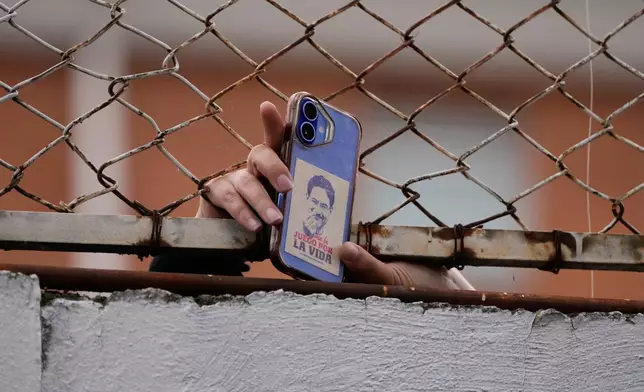 A supporter shows a phone case decorated with a sticker of presidential candidate Ivan Cepeda of the ruling Historic Pact coalition at the polling station where he voted during the runoff election in Bogota, Colombia, Sunday, June 21, 2026. (AP Photo/Fernando Vergara)
