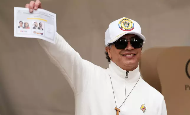 Colombian President Gustavo Petro shows a ballot during the runoff election in Bogota, Colombia, Sunday, June 21, 2026. (AP Photo/Fernando Vergara)