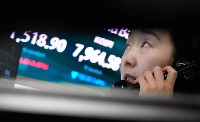 A currency trader talks on the phone near a screen showing the Korea Composite Stock Price Index (KOSPI) and the foreign exchange rate between U.S. dollar and South Korean won at the foreign exchange dealing room of the Hana Bank headquarters in Seoul, South Korea, Wednesday, June 10, 2026. (AP Photo/Ahn Young-joon)