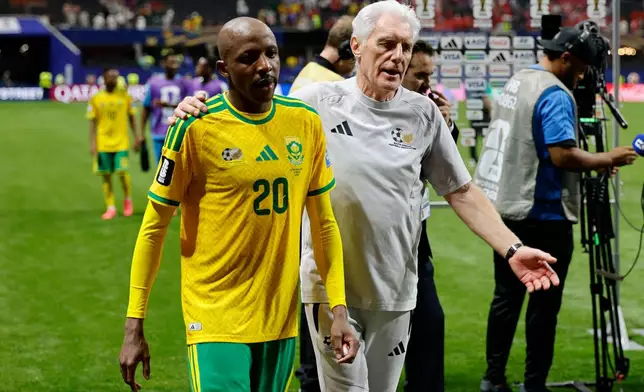 South Africa's Khuliso Mudau, left, and South Africa head coach Hugo Broos leave the pitch after the World Cup Group A soccer match between Czechia and South Africa in Atlanta, Thursday, June 18, 2026. (AP Photo/Erik S. Lesser)