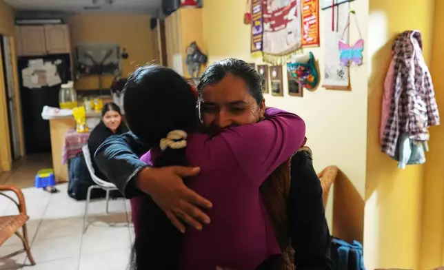 Mirsy Maricela Alva Lopez, right, embraces a relative as she and her children return to the home they all shared in West Palm Beach, Fla., nearly one year after being separated by the U.S. government for the second time, Thursday, May 28, 2026. (AP Photo/Rebecca Blackwell)