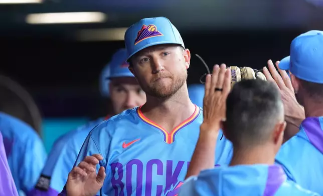 Colorado Rockies starting pitcher Kyle Freeland, center, is congratulated as he returns to the dugout after he was pulled from the mound in the eighth inning of a baseball game against the Pittsburgh Pirates, Friday, June 19, 2026, in Denver. (AP Photo/David Zalubowski)