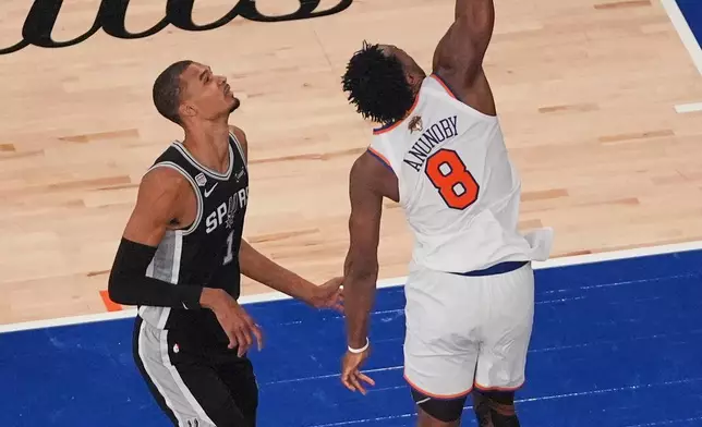 New York Knicks forward Og Anunoby (8) dunks over San Antonio Spurs forward Victor Wembanyama (1) during the second half of Game 4 of the NBA Finals basketball series, Wednesday, June 10, 2026, in New York. (AP Photo/Frank Franklin II)