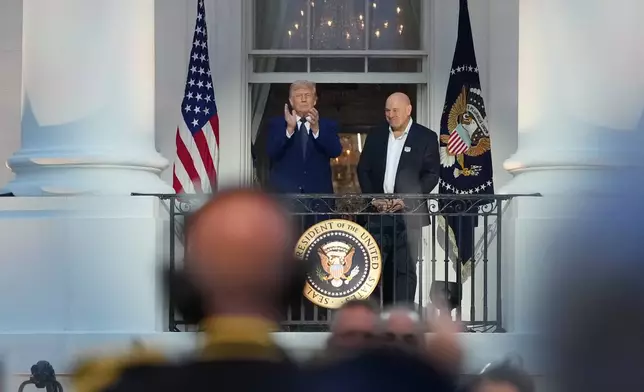 President Donald Trump and Dana White, UFC president and CEO, arrive on the Blue Room Balcony for the National Anthem before UFC Freedom 250 on the South Lawn of the White House, Sunday, June 14, 2026, in Washington. (AP Photo/Alex Brandon)