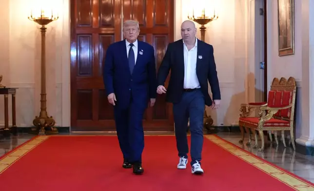 President Donald Trump walks with UFC president and CEO Dana White through the Cross Hall of the White House before attending the UFC Freedom 250 fights on the South Lawn of the White House, Sunday, June 14, 2026, in Washington. (AP Photo/Jacquelyn Martin, Pool)