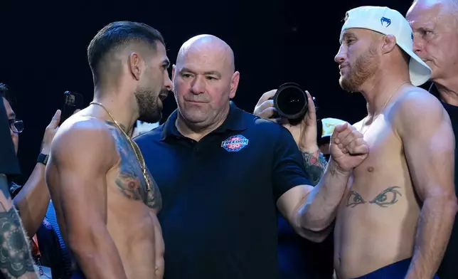 UFC commentator Joe Rogan, center, with Ilia Topuria, left, and Justin Gaethje, right, during the ceremonial UFC Freedom 250 weigh-ins on the Ellipse, Saturday, June 13, 2026, in Washington, ahead of Sunday's fight on the South Lawn of the White House. (AP Photo/Julia Demaree Nikhinson)