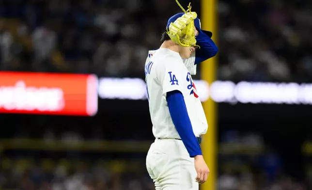 Los Angeles Dodgers starting pitcher Roki Sasaki wipes his sweat during the sixth inning of a baseball game against the Baltimore Orioles in Los Angeles, Friday, June 19, 2026. (AP Photo/Kyusung Gong)