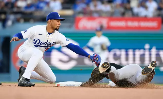 Los Angeles Dodgers shortstop Mookie Betts, left, tags out Baltimore Orioles' Taylor Ward, right, during the first inning of a baseball game in Los Angeles, Friday, June 19, 2026. (AP Photo/Kyusung Gong)