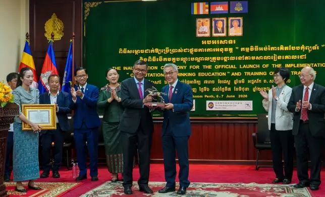 Dr Hang Chuon Naron, Deputy Prime Minister and Minister of Education, Youth and Sports, Cambodia (left) and Jackson Woo, Trustee of The Hong Kong Jockey Club Charities Trust (right) exchange gifts.
