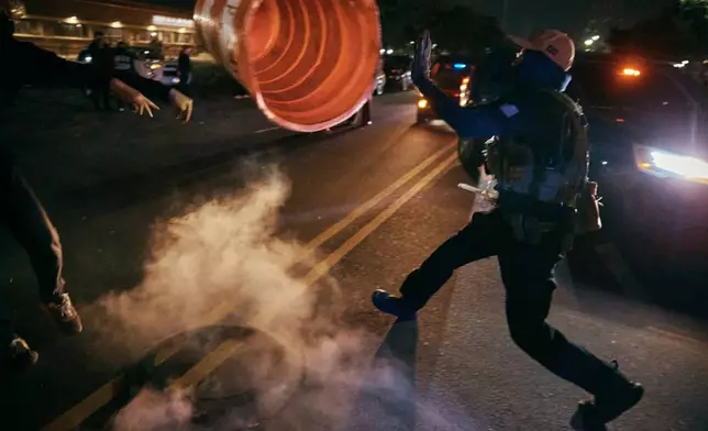 A protester throws a traffic cone to an ICE agent outside the Delaney Hall detention center during a protest on Wednesday, May 27, 2026, in Newark, N.J. (AP Photo/Andres Kudacki)