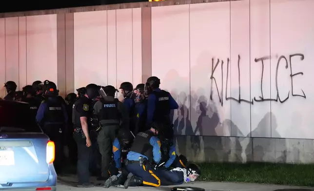 Law enforcement officers detain a protester outside Delaney Hall detention center Sunday, May 31, 2026, in Newark, N.J. (AP Photo/Adam Gray)