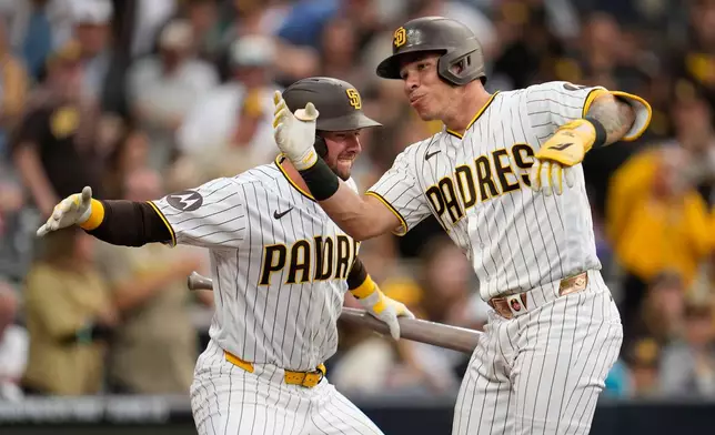 San Diego Padres' Freddy Fermin, right, celebrates with teammate Jackson Merrill after hitting a home run during the third inning of a baseball game against the Cincinnati Reds Monday, June 8, 2026, in San Diego. (AP Photo/Gregory Bull)