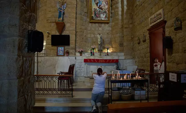 A woman prays inside St. George Church in the southern village of Qlayaa, Lebanon, Wednesday, June 10, 2026. (AP Photo/Hassan Ammar)