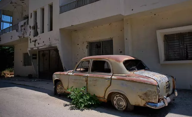 A damaged building and an abandoned car are seen in the southern town of Marjayoun, Lebanon, Thursday, June 11, 2026. (AP Photo/Hassan Ammar)