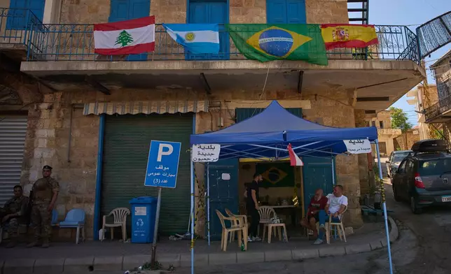 Lebanese soldiers stand guard near a municipal checkpoint decorated with Lebanese, Argentine, Brazilian and Spanish flags hung by residents in support of their favorite teams ahead of the FIFA World Cup in the southern town of Marjayoun, Lebanon, Wednesday, June 10, 2026. (AP Photo/Hassan Ammar)