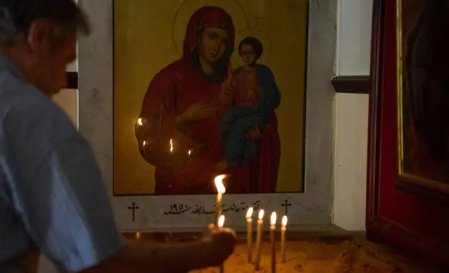 A man lights candles inside St. Georges Orthodox Church in the southern town of Marjayoun, Lebanon, Wednesday, June 10, 2026. (AP Photo/Hassan Ammar)