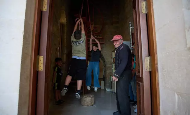 Children ring the bell of St. Georges Church in the southern village of Qlayaa, Lebanon, Wednesday, June 10, 2026. (AP Photo/Hassan Ammar)
