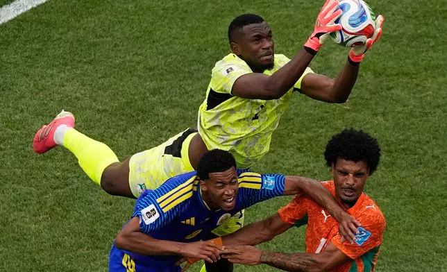 Ivory Coast goalkeeper Yahia Fofana (1) makes a save in front of Curaçao's Livano Comenencia (8) and Ivory Coast's Christopher Operi (13) during the World Cup Group E soccer match between Curacao and Ivory Coast in Philadelphia, Thursday, June 25, 2026. (AP Photo/Matt Slocum)