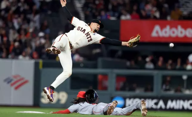 Washington Nationals shortstop CJ Abrams, right, steals second base as San Francisco Giants shortstop Willy Adames fields the throw during the ninth inning of a baseball game in San Francisco, Monday, June 8, 2026. (AP Photo/Jed Jacobsohn)