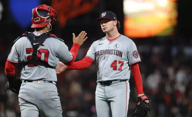 Washington Nationals pitcher Gus Varland (47) celebrates with catcher Keibert Ruiz (20) after their team's victory against the San Francisco Giants duriing a baseball game in San Francisco, Monday, June 8, 2026. (AP Photo/Jed Jacobsohn)