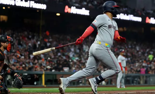 Washington Nationals' Luis García Jr., right, hits an RBI single in front of San Francisco Giants catcher Eric Haase, left, during the sixth inning of a baseball game in San Francisco, Monday, June 8, 2026. (AP Photo/Jed Jacobsohn)