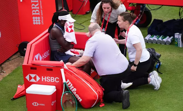 Victoria Mboko, left, of Canada retires injured during her match against Karolina Pliskova of Czech Republic on day three of the Queen's Club tennis championships in London, Wednesday, June 10, 2026. (Ben Whitley/PA via AP)
