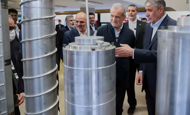 FILE - In this photo released by the Iranian Presidency Office, President Masoud Pezeshkian, second right, listens to head of Atomic Energy Organization of Iran Mohammad Eslami as he visits an exhibition of Iran's nuclear achievements, in Tehran, Iran, April 9, 2025. (Iranian Presidency Office via AP, File)