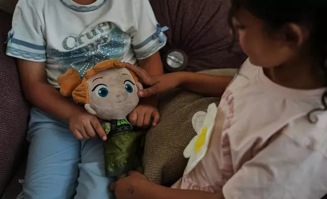 Palestinian orphan sisters Nabila and Basmala Al-Kafarna play with a doll at their home in Gaza City, May 31, 2026. Their parents were killed in an Israeli airstrike that struck a school sheltering displaced people on April 3, 2025. (AP Photo/Abdel Kareem Hana)