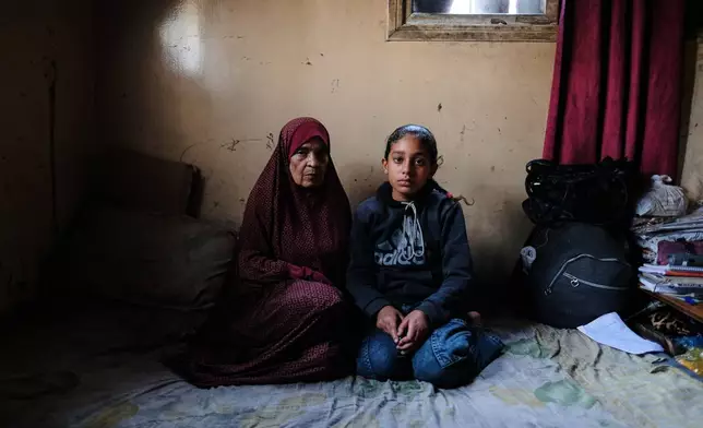 Eleven-year-old Ghazal al-Kibritti, who lost her parents and three siblings in an Israeli airstrike, poses with her grandmother, Huda al-Salti, at the Gaza City home where she now lives with her grandparents, Sunday, April 26, 2026. (AP Photo/Jehad Alshrafi)