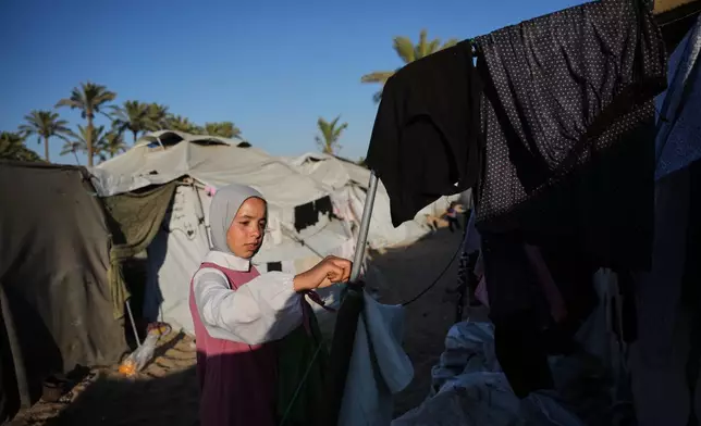 Palestinian orphan Dina Zourob, 17, hangs laundry outside her tent at an orphanage camp in Khan Younis, southern Gaza Strip, Sunday, June 7, 2026. (AP Photo/Abdel Kareem Hana)