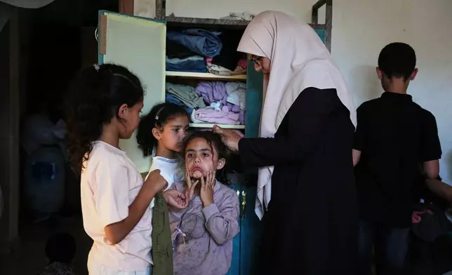 Ikhlas al-Kafarna, 35, cares for her orphaned nieces and nephews at her home in Gaza City, May 31, 2026. The children lost their parents in an Israeli airstrike. (AP Photo/Abdel Kareem Hana)