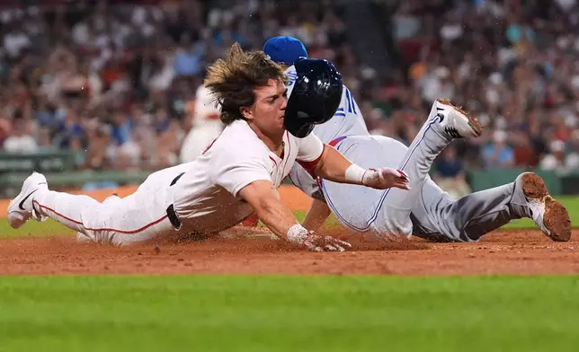 Boston Red Sox pinchhitter Nate Eaton, left, dives into first base head first as Toronto Blue Jays' Vladimir Guerrero Jr. makes the force out with bases loaded to end the fifth inning of a baseball game, Wednesday, June 17, 2026, in Boston. (AP Photo/Charles Krupa)