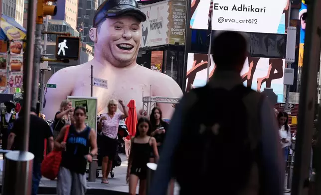 A large inflatable figure depicting Elon Musk stands in Times Square in New York on Thursday, June 11, 2026. (AP Photo/Seth Wenig)