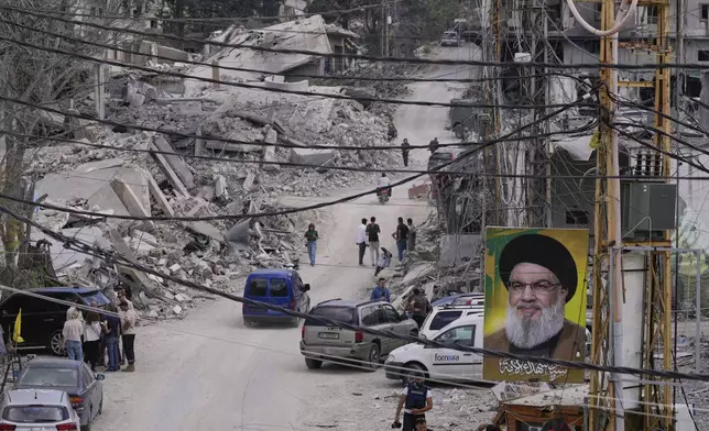 People who return to their village following the announcement of an initial ceasefire agreement between the United States and Iran, gather with journalists at a destroyed street in Beer al-Salassel, south Lebanon, Monday, June 15, 2026. (AP Photo/Mohammed Zaatari)