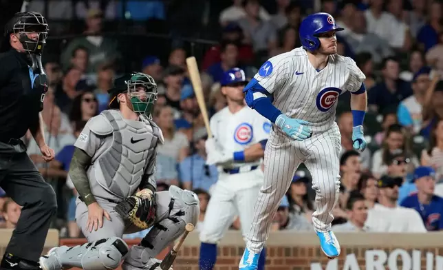 Chicago Cubs' Ian Happ, right, runs after hitting a one-run double during the ninth inning of a baseball game against the Athletics in Chicago, Thursday, June 4, 2026. (AP Photo/Nam Y. Huh)