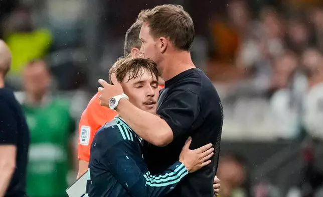 Germany's Lennart Karl, left, is hugged by coach Julian Nagelsmann during the friendly soccer match between Germany and Finland in Mainz, Germany, Sunday, May 31, 2026. (AP Photo/Michael Probst)