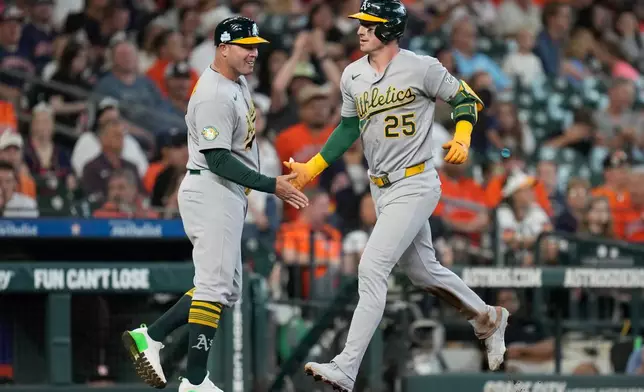 Athletics designated hitter Brent Rooker (25) celebrates after his solo home run against the Houston Astros with third base coach Bobby Crosby during the fifth inning of a baseball game, Sunday, June 7, 2026, in Houston. (AP Photo/Eric Christian Smith)