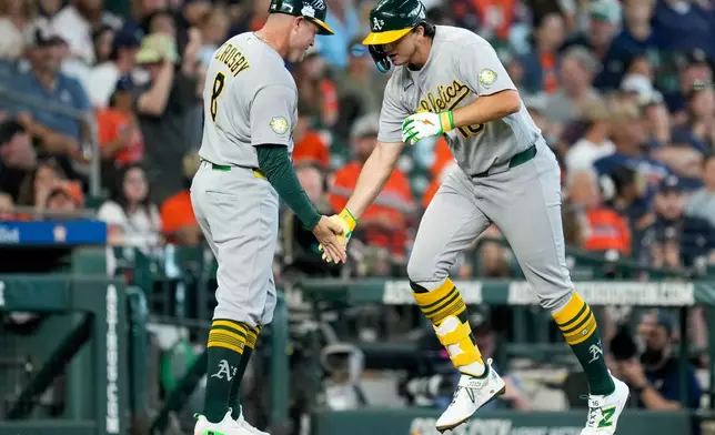 Athletics' Nick Kurtz, right, celebrates after his two-run home run against the Houston Astros with thrid base coach Bobby Crosby during the third inning of a baseball game, Sunday, June 7, 2026, in Houston. (AP Photo/Eric Christian Smith)
