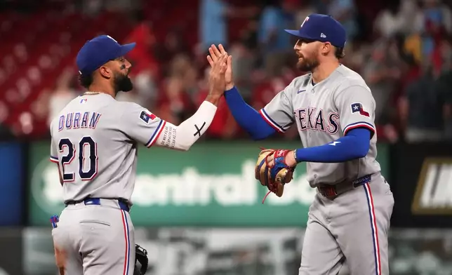 Texas Rangers' Ezequiel Duran (20) and Brandon Nimmo celebrate a victory over the St. Louis Cardinals in a baseball game Monday, June 1, 2026, in St. Louis. (AP Photo/Jeff Roberson)