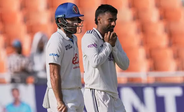 Afghanistan's Rahmat Shah, left, looks on as India's Manav Suthar takes the catch to dismiss Afghanistan's Afsar Zazai off his own bowling on day two of the cricket test match between Afghanistan and India in New Chandigarh, India, Sunday, June 7, 2026. (AP Photo/Ashwini Bhatia)