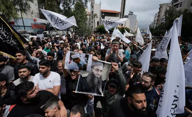 FILE - Sunni Muslims hold a portrait of imprisoned Sunni cleric Ahmad al-Assir, center right, during a protest against the clause in a proposed amnesty law that would exclude some prisoners, including the cleric, from being eligible for amnesty, after Friday prayers in Beirut, Lebanon, Friday, May 22, 2026. (AP Photo/Bilal Hussein, File)