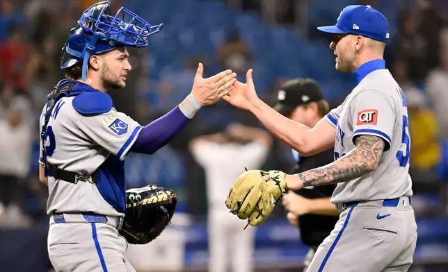Kansas City Royals catcher Carter Jensen, left, and pitcher Alex Lange, right, celebrate after a win over the Tampa Bay Rays in a baseball game Monday, June 22, 2026, in St. Petersburg, Fla. (AP Photo/Jason Behnken)