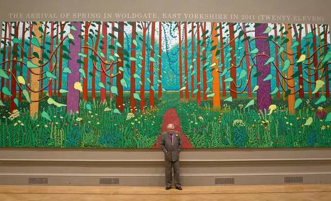 FILE - British artist David Hockney stands before one of his paintings of the East Yorkshire landscape at The Royal Academy of Arts in Piccadilly, London, Monday, Jan. 16, 2012, ahead of his exhibition called 'A Bigger Picture'. (AP Photo/Joel Ryan)