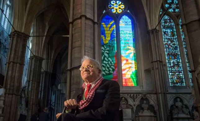 FILE - British artist David Hockney sits in front of The Queen's Window, a new stained glass window at Westminster Abbey, London, designed by David Hockney and revealed for the first time on Wednesday Sept. 26, 2018. (Victoria Jones/Pool via AP, File)