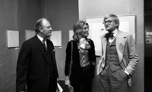 FILE - Painter David Hockney, right, with British Ambassador Edward Tomkins, left, at the opening of his exhibition at Musee des Arts Decoratifs on Oct. 10, 1974 in Paris. (AP Photo/Michel Lipchitz, File)