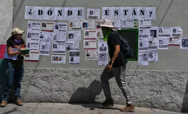 Activists and families of the country's more than 134,000 disappeared people paste missing-person posters in Mexico City, Saturday, May 30, 2026, as Mexico prepares to host the 2026 FIFA World Cup. (AP Photo/Marco Ugarte)